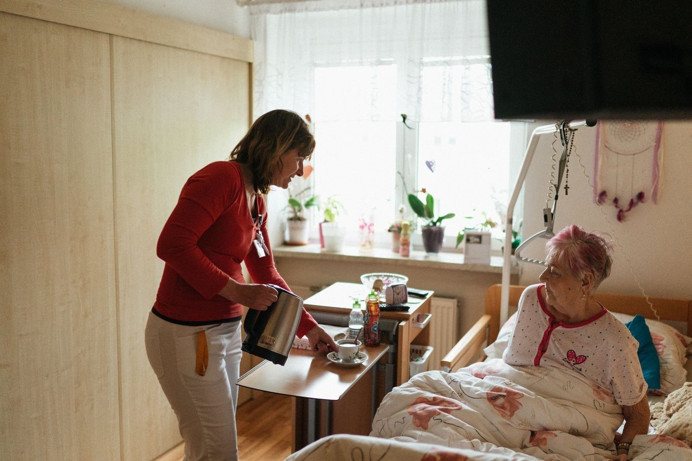 Aide-soignante apportant un plateau à une résidente en EHPAD